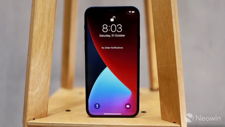 iPhone 12 standing vertically on a wooden surface