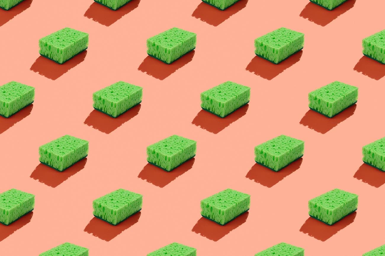 Πράσινα σφουγγάρια σε ροζ φόντο που συμβολίζουν το πράσινο πλύσιμο.