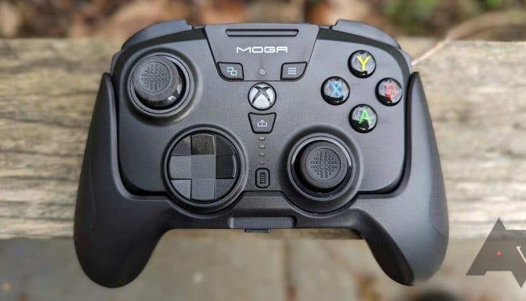 black game controller resting on wooden fence