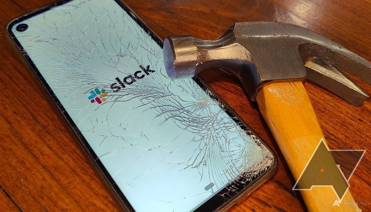 A smartphone displays the Slack logo through a cracked display while a hammer rests on the screen