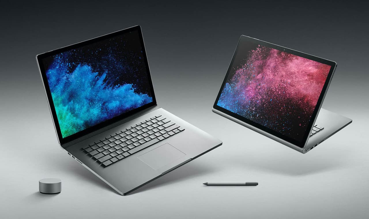 Δύο Surface Book 2 το ένα δίπλα στο άλλο με Surface Dial και Surface Pen