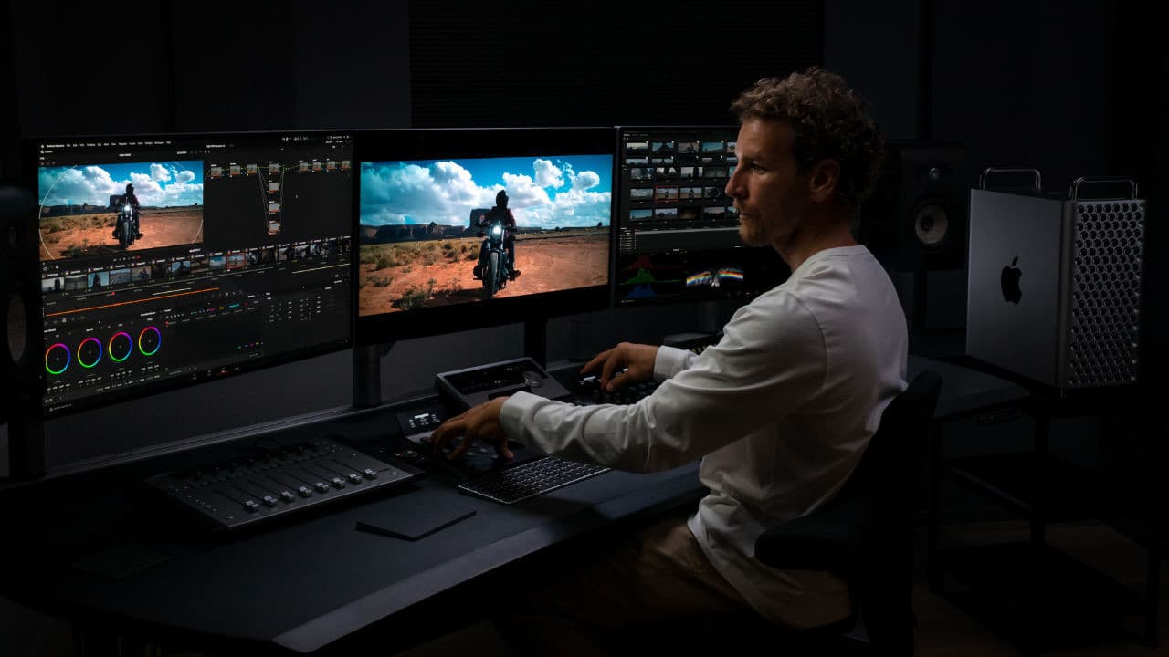 Ένα άτομο που εργάζεται με το Mac Pro και τρεις οθόνες