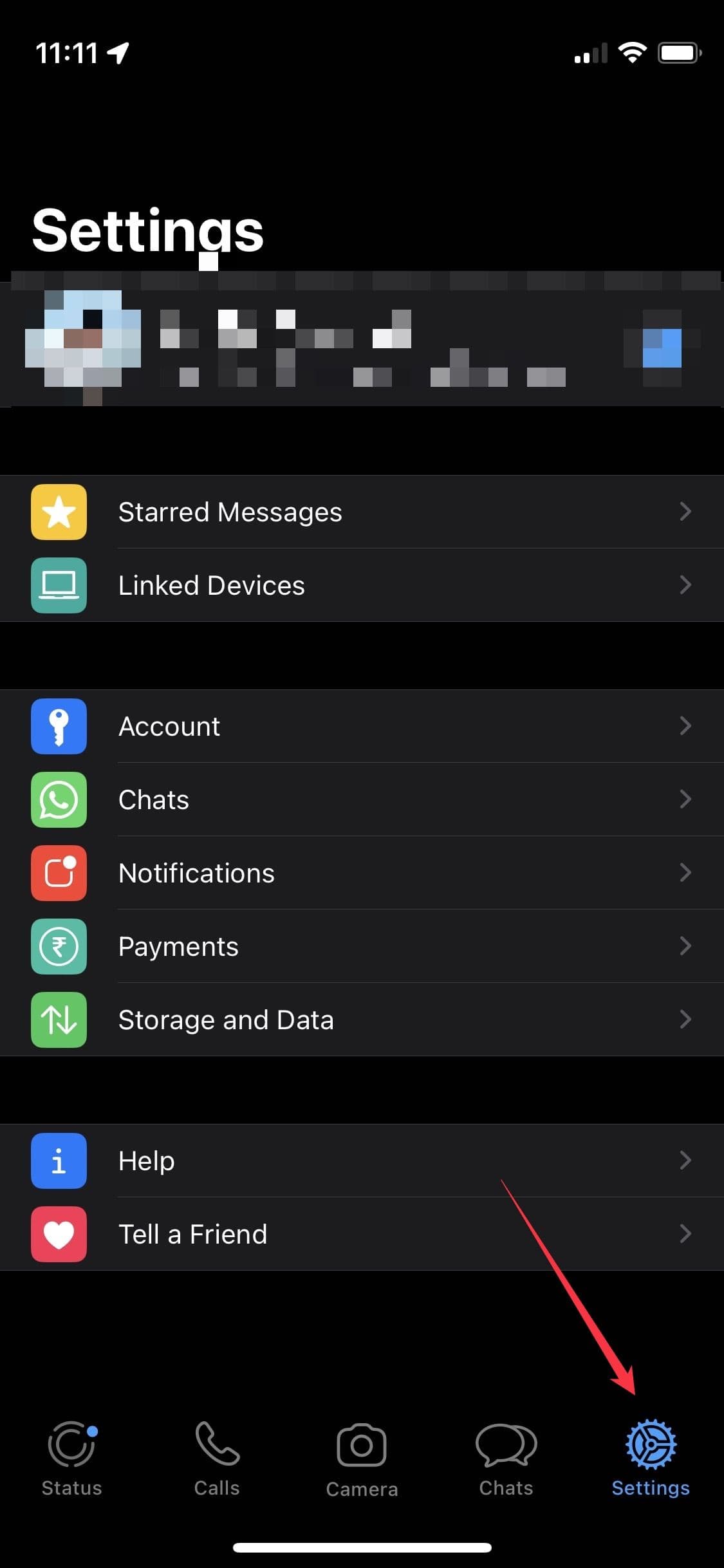 Ένα στιγμιότυπο οθόνης της εφαρμογής WhatsApp για iPhone δείχνει ένα βέλος που δείχνει το κουμπί Ρυθμίσεις.