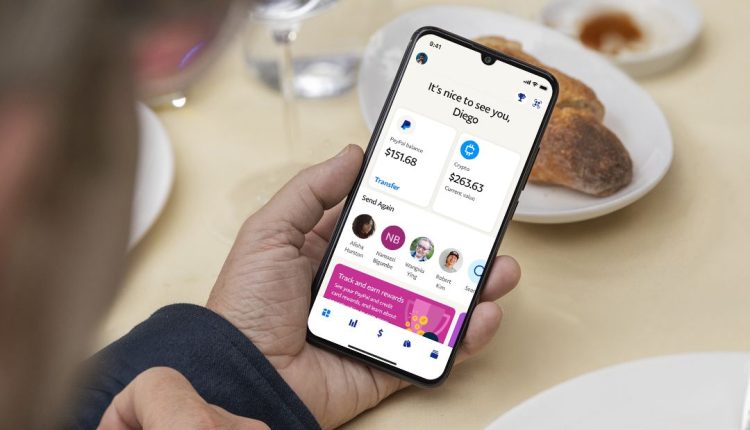 hand holding phone showing paypal app