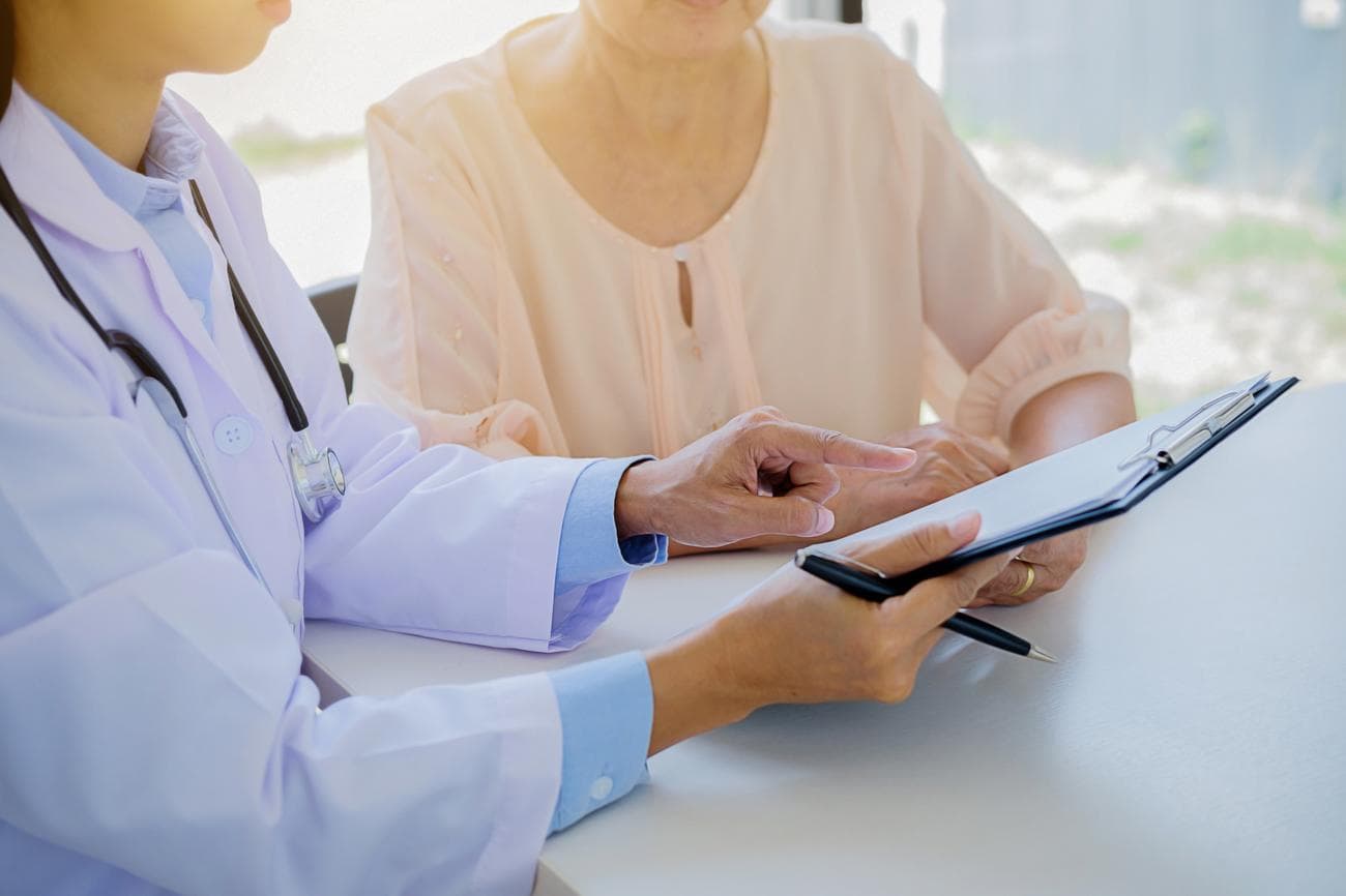 Γυναίκα γιατρός που δείχνει πρόχειρο στον ασθενή στο νοσοκομείο