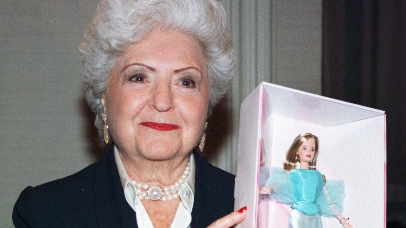 Μια εικόνα της Ruth Handler να κρατά ψηλά μια κούκλα Barbie. 
