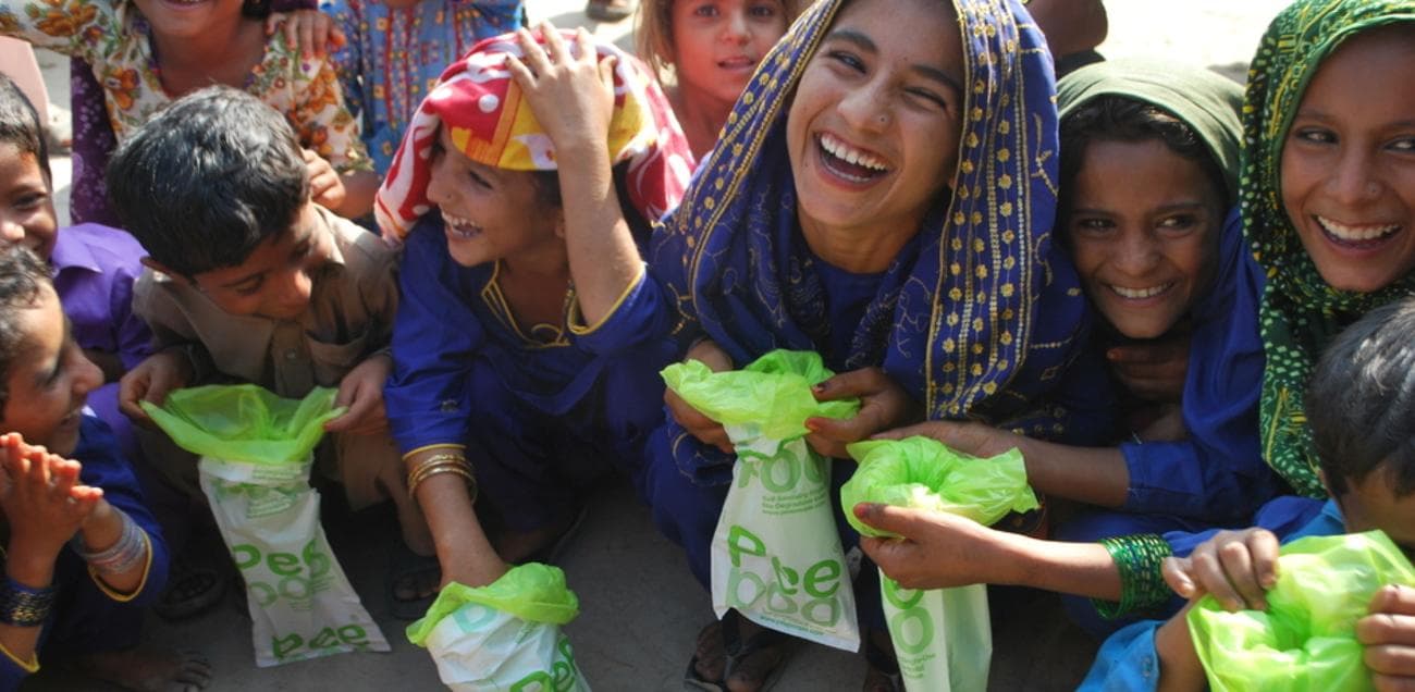 Several people smiling while holding Peepoo Toilets.