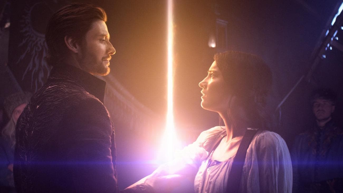 A man holds a woman's arm from which light power is beaming.