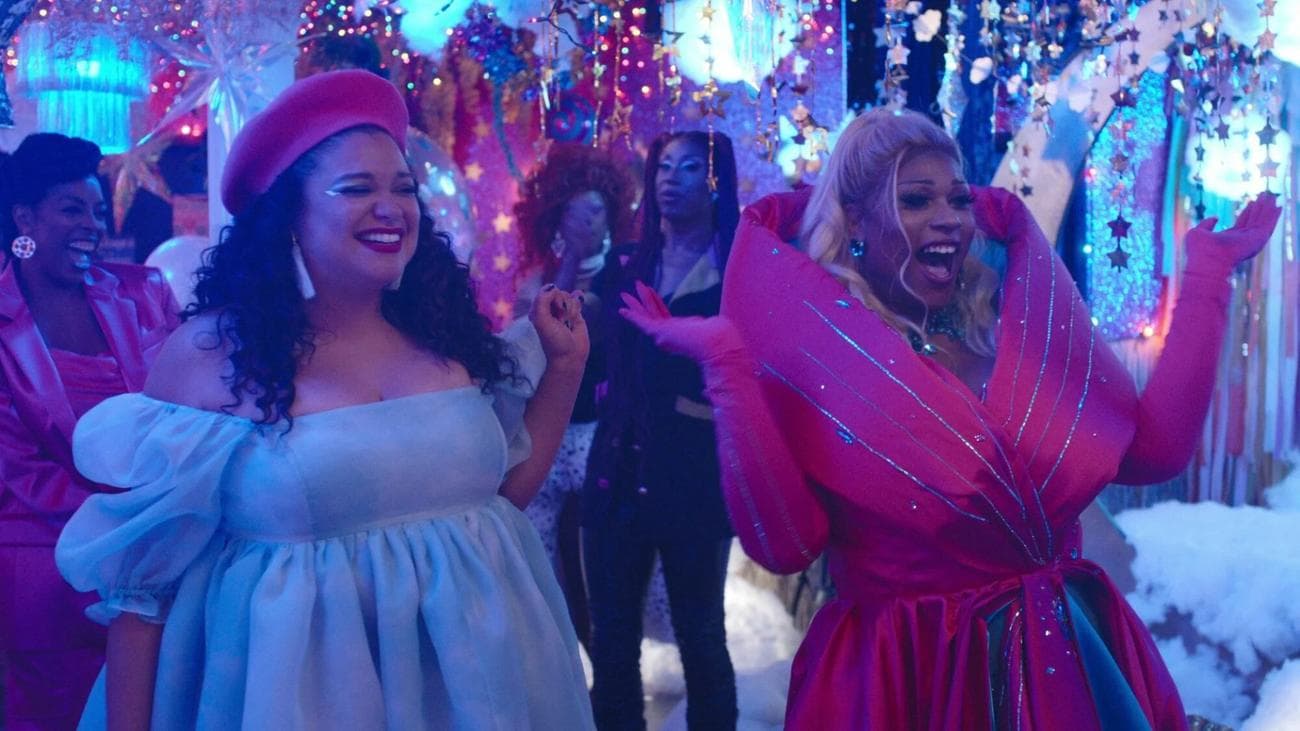 Δύο γυναίκες που φορούν φωτεινά φορέματα ζητωκραυγάζουν σε ένα πάρτι. 