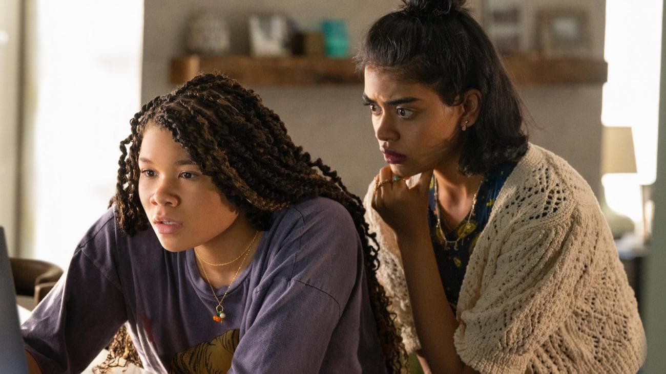 Storm Reid and Megan Suri look worried reading a computer screen in the film 