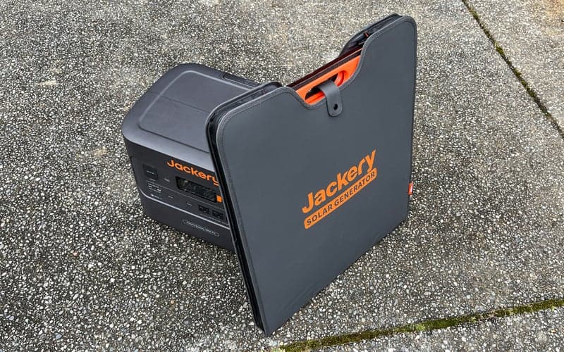 Jackery Explorer 3000 solar generator with its solar panels sitting on pavement