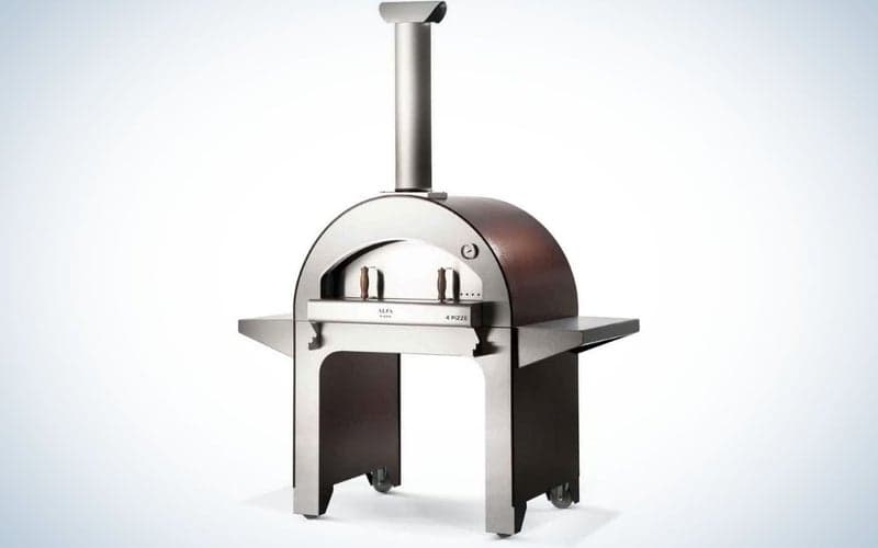 Ένας μεγάλος φούρνος όλο μεταλλικό και ασημί χρώμα, με μακρύ σωλήνα σε σχήμα καμινάδας και φαρδύ από κάτω για να δημιουργεί χώρο για ψήσιμο που θα γίνει σε αυτόν.