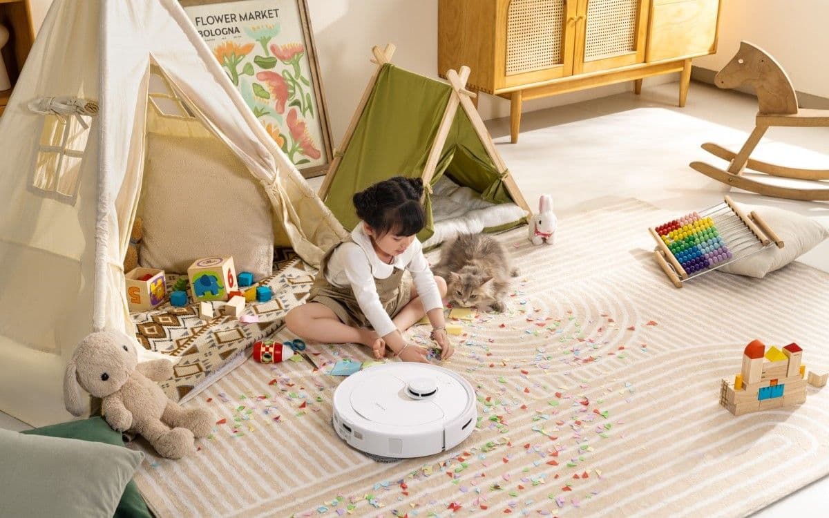 Παιδί που παίζει στο χαλί με τον Roborock Q Revo δίπλα της