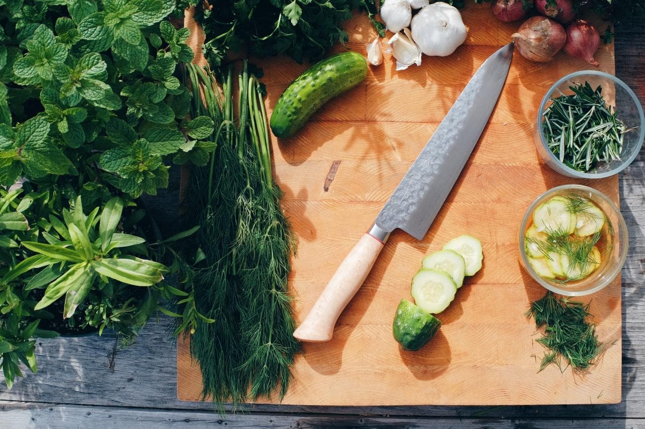 Vegetables and knife on wooden cutting board