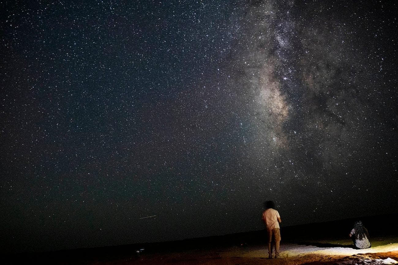 12 Αυγούστου 2023, Αίγυπτος, Φαγιούμ: Μια φωτογραφία που τραβήχτηκε στις 12 Αυγούστου δείχνει ανθρώπους να παρακολουθούν τη βροχή μετεωριτών των Περσείδων πάνω από τη φυσική αποθεματική περιοχή Wadi Al-Hitan (Κοιλάδα των Φαλαινών) στην έρημο του Κυβερνείου Al Fayoum.  Φωτογραφία: Gehad Hamdy/dpa (Φωτογραφία Gehad Hamdy/συμμαχία εικόνας μέσω Getty Images)