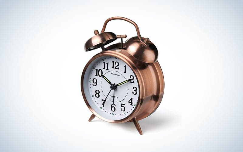 A gold alarm clock on a blue and white background