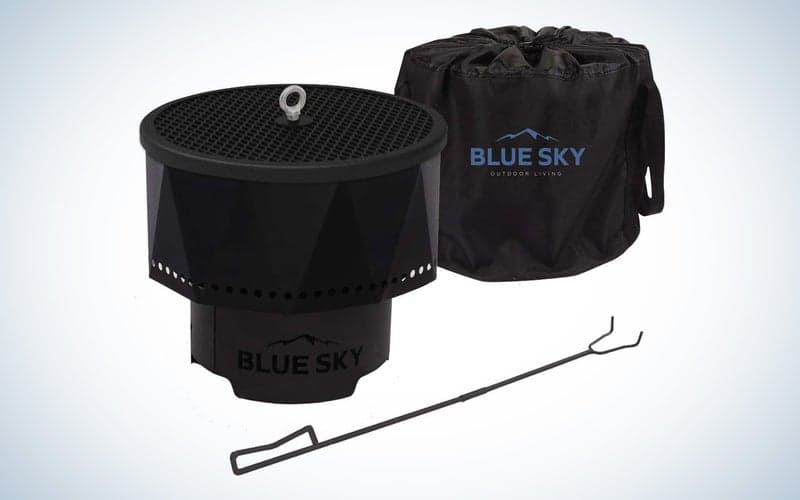The Blue Sky fire pit with its cover and wood poker on a plain background