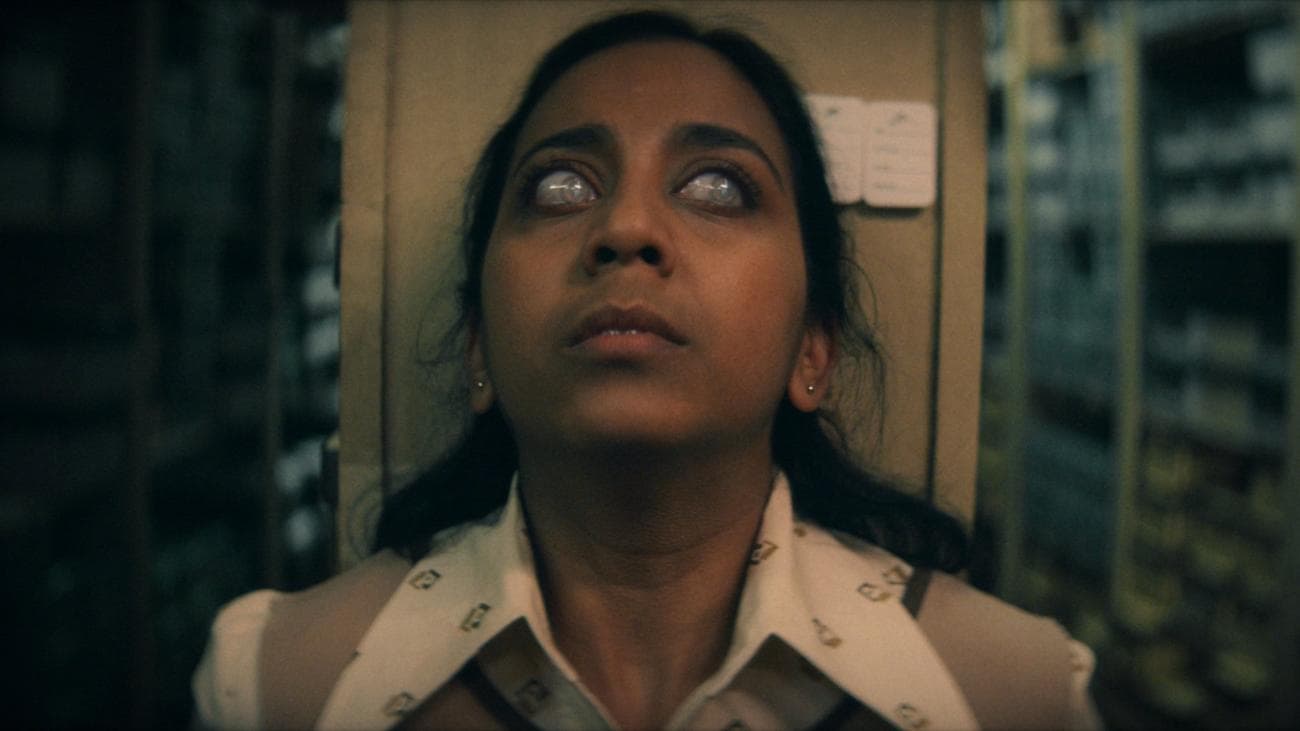 Anjana Vasan looks scared with glazed eyes as if possessed in "Black Mirror"