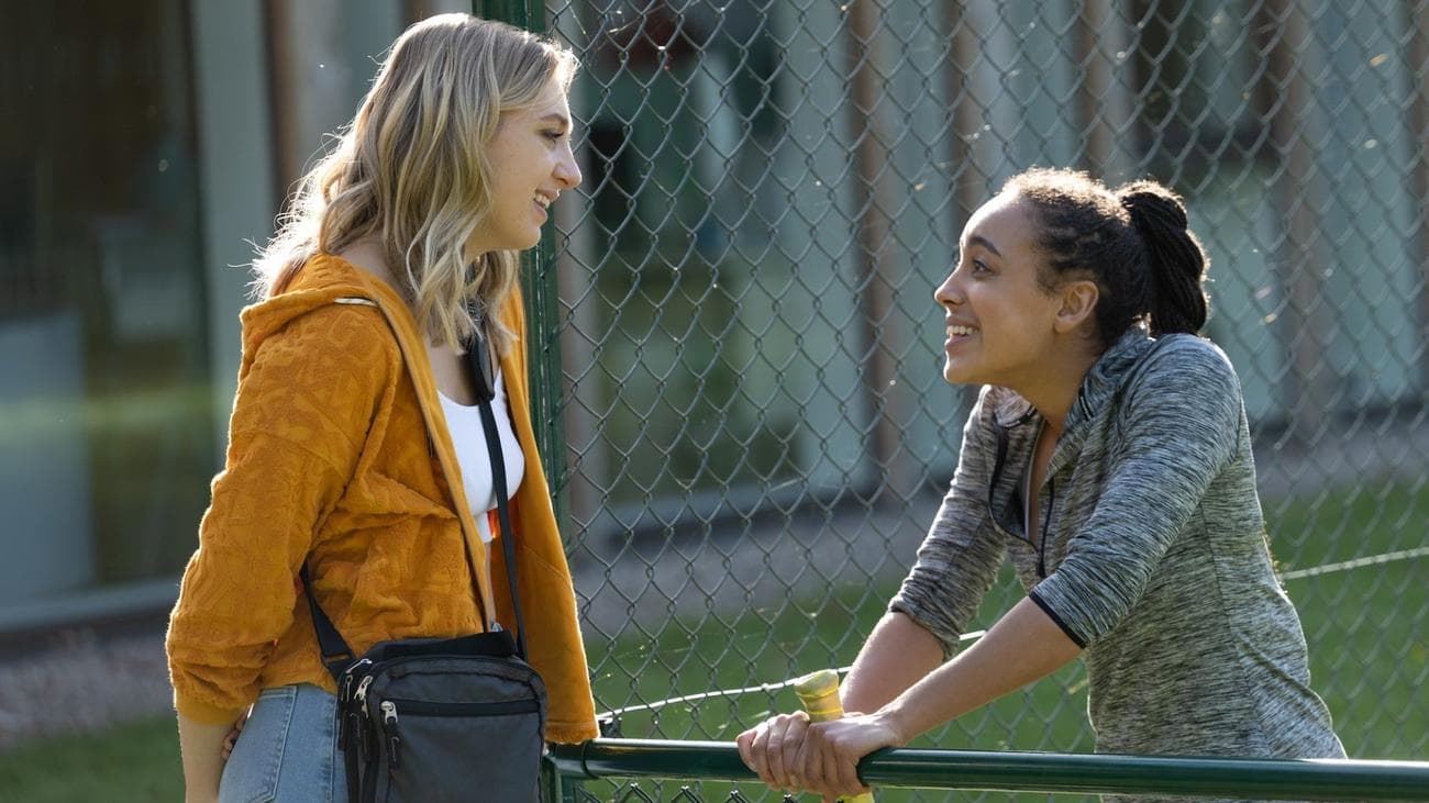 Ella Lily Hyland and Harmony Rose Bremner stand chatting on a tennis court in the show "Fifteen-Love"
