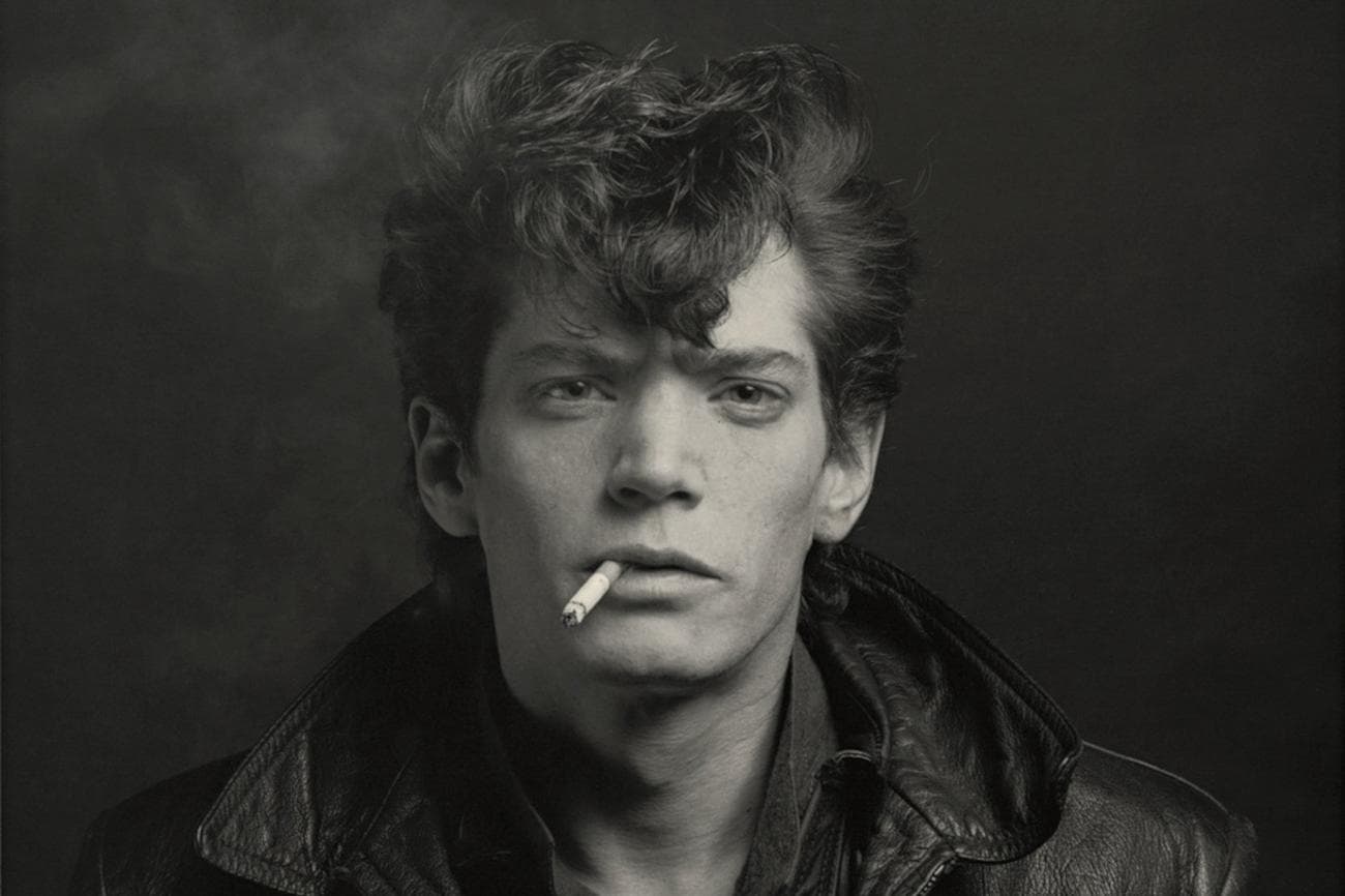 A portrait of Robert Mapplethorpe smoking.