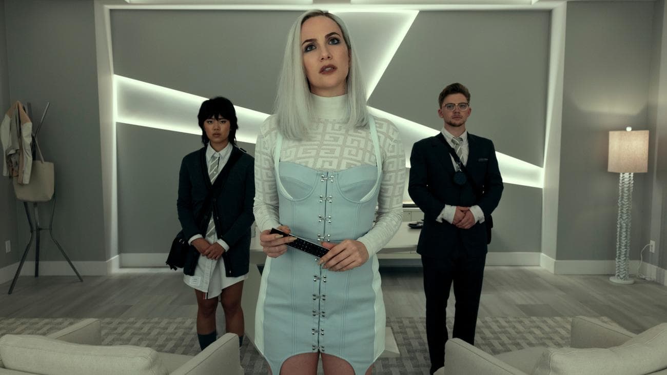 Τρία άτομα με μοντέρνα ρούχα στέκονται σε ένα μοντέρνο γραφείο.