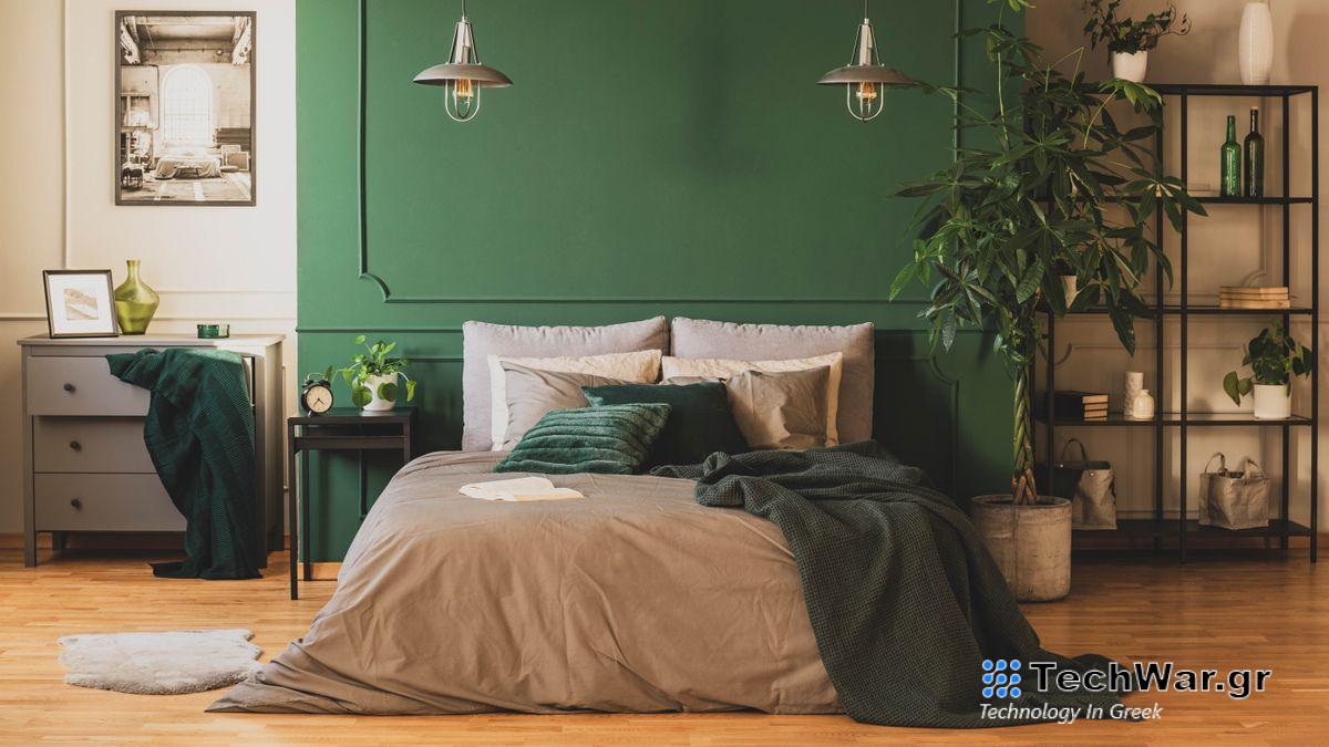 A bedroom with a large plant next to the bed