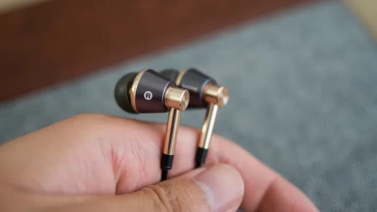 Κάποιος που κρατά τα ακουστικά 1More Triple Driver In-Ear.