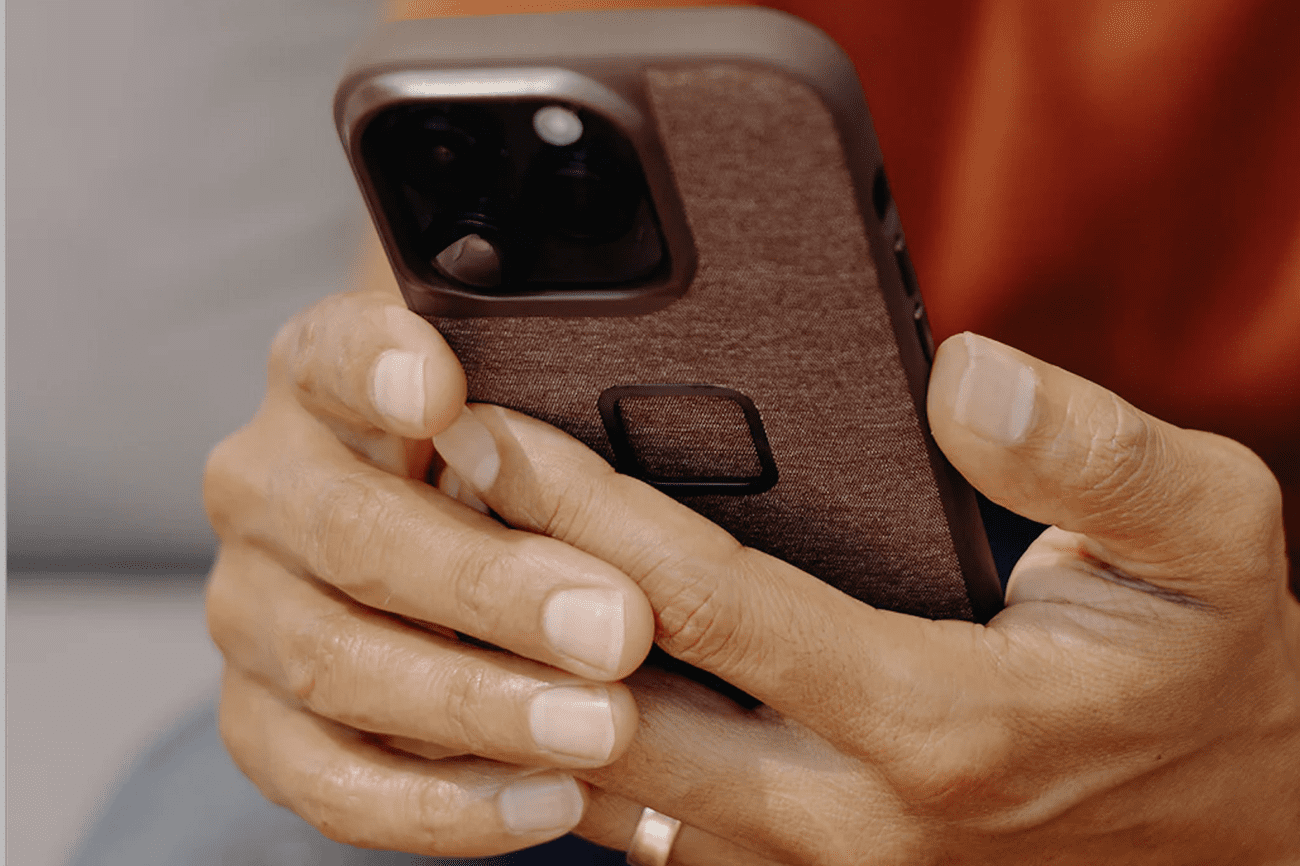 Hands holding iPhone in case.