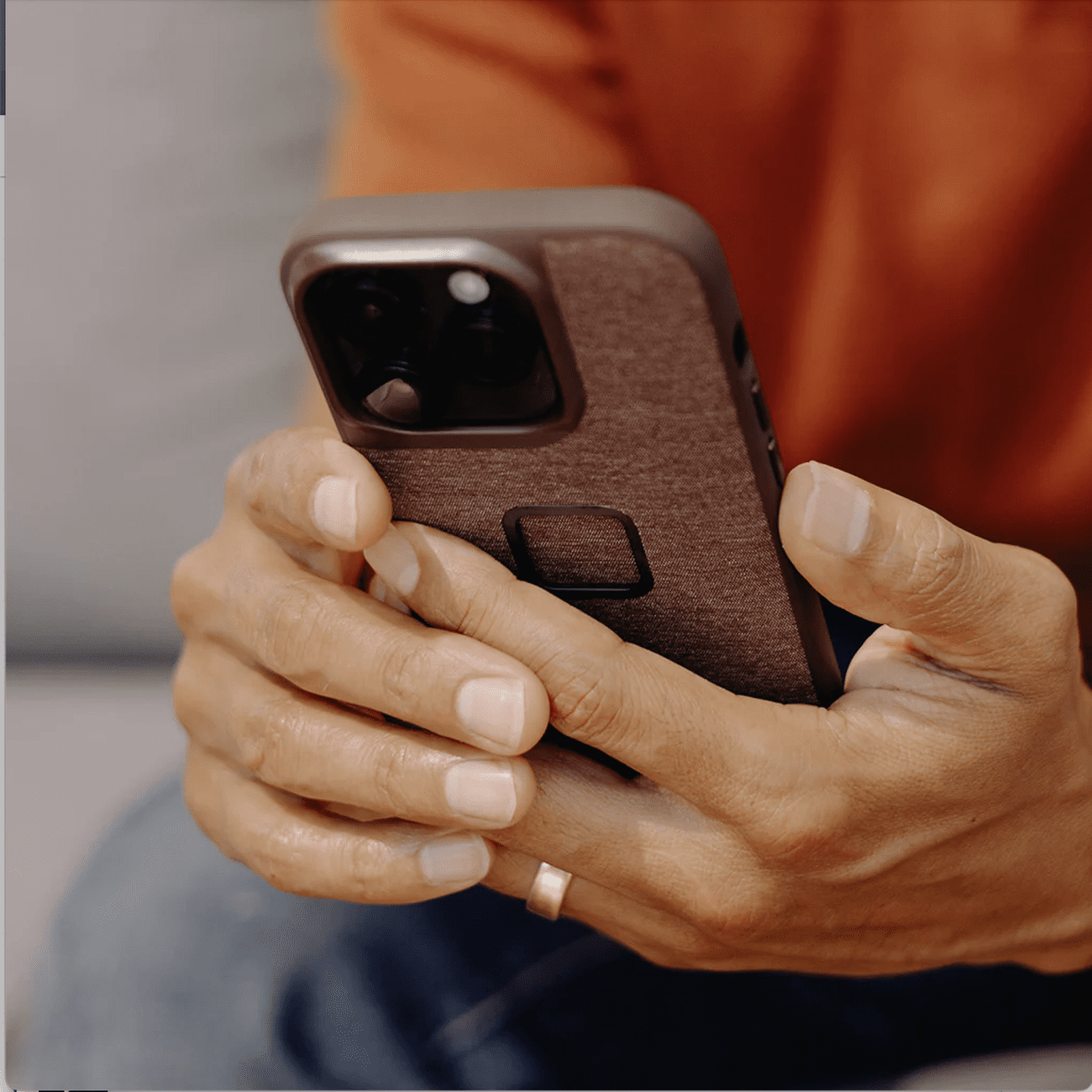 Hands holding iPhone in case.