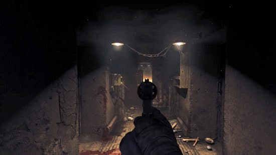 A man off-screen holding a pistol in front of him as he walks down a cluttered bunker corridor in one of the best horror games, Amnesia: The Bunker.