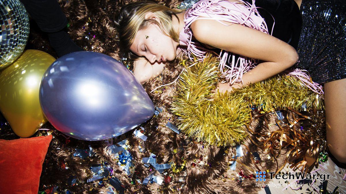 A woman with blonde hair falls asleep on the floor after a New Year