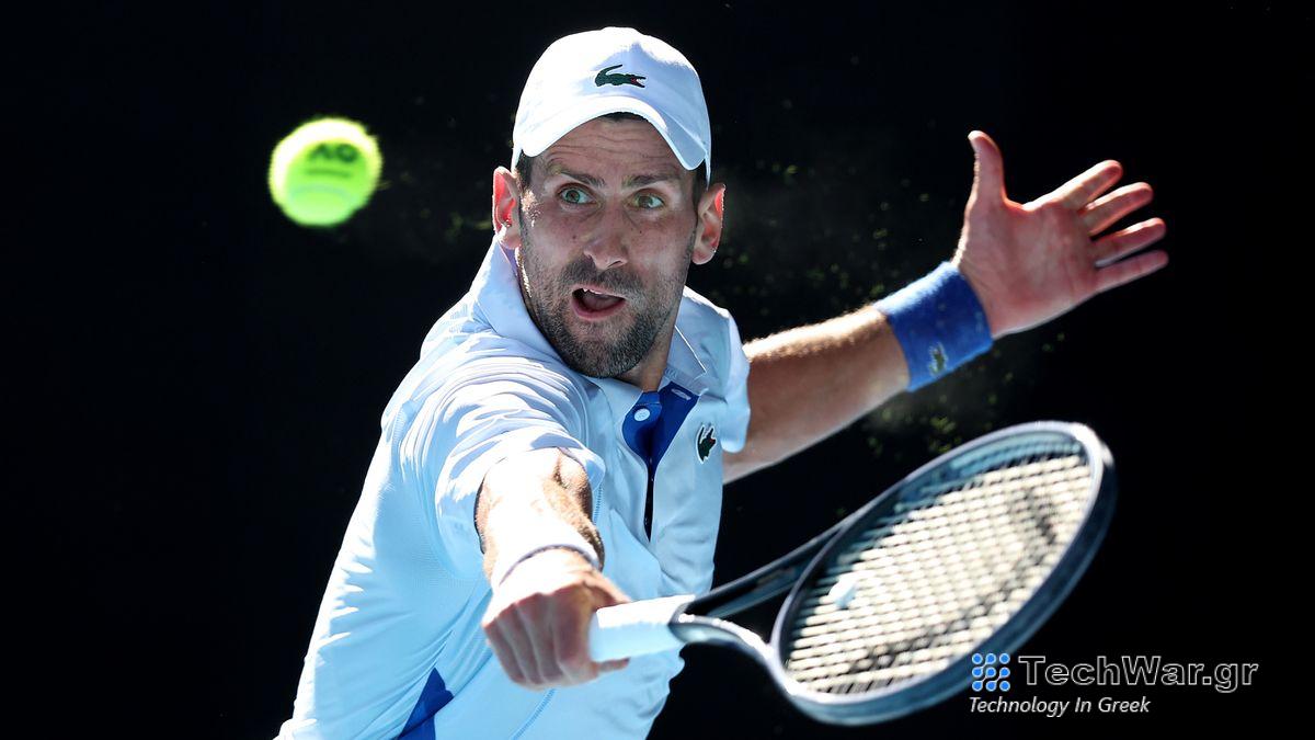 Novak Djokovic of Serbia, wearing white baseball cap and shirt, plays a backhand at the Australian Open 2024 Grand Slam tennis tournament.