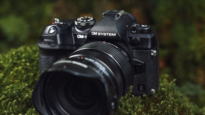 Το OM System OM-1 II είναι μια ανανέωση μιας από OM System OM-1 II mirrorless camera resting on a mossy rock