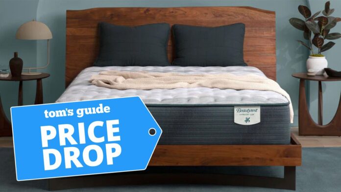 Beautyrest Harmony Lux mattress placed on a wooden bedframe with a blue price drop sales badge overlaid