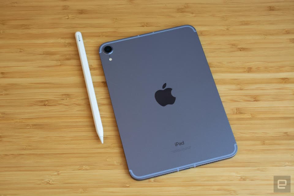 Φωτογραφία του iPad mini 6ης γενιάς που κάθεται σε ένα κομψό ξύλινο τραπέζι με την πλάτη του (με το λογότυπο της Apple) προς τα επάνω.  Το Apple Pencil του βρίσκεται στα αριστερά του.