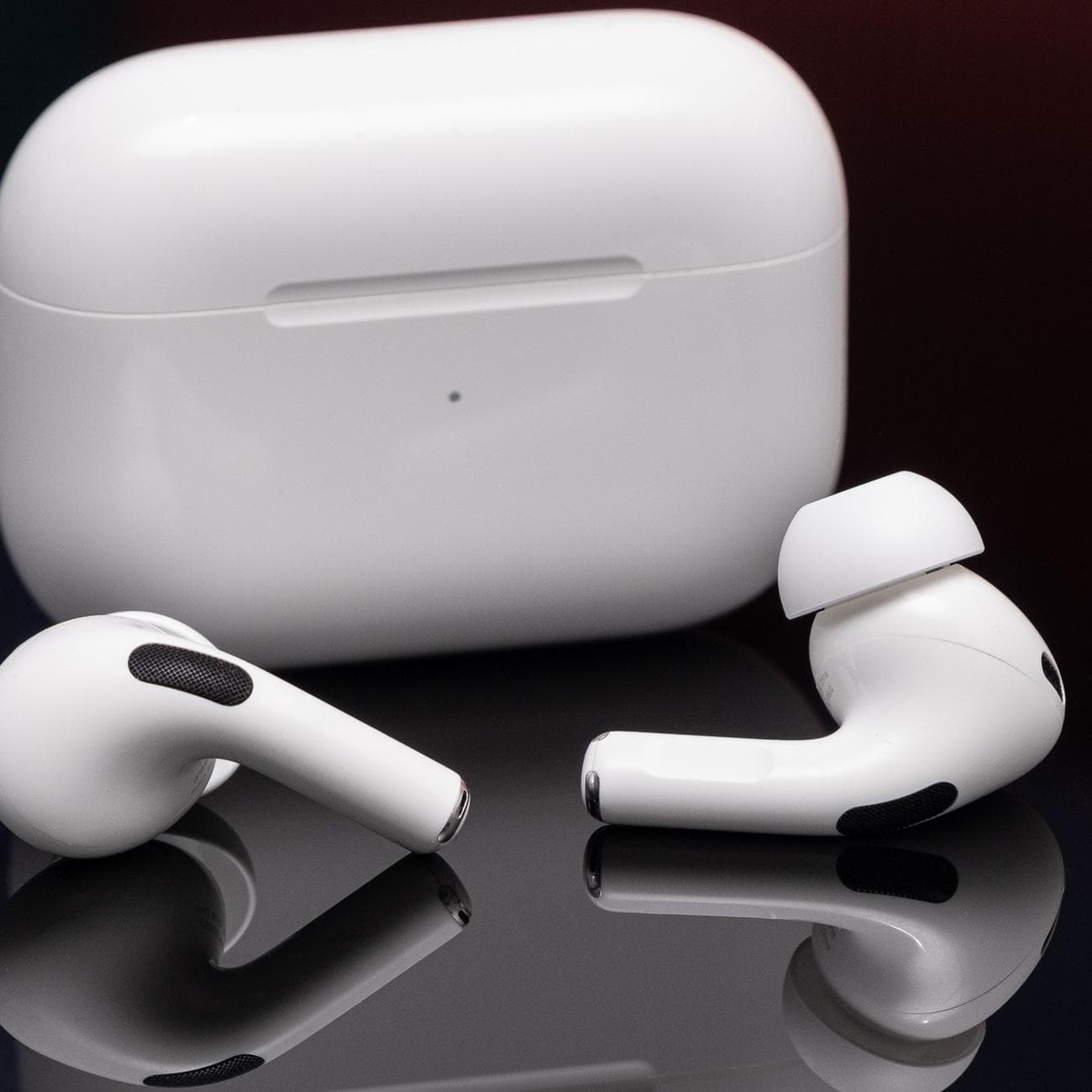 Apple's second-generation AirPods Pro photographed on a reflective black surface.