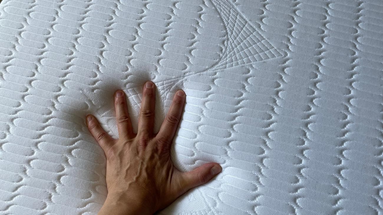Feeling the top cover of the REM-Fit Pocket 1000 mattress