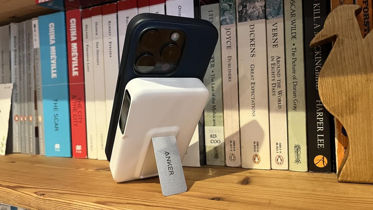 Το Anker MagGo Power Bank (10K) συνδεδεμένο με ένα iPhone 15 Pro σε ένα ξύλινο ράφι