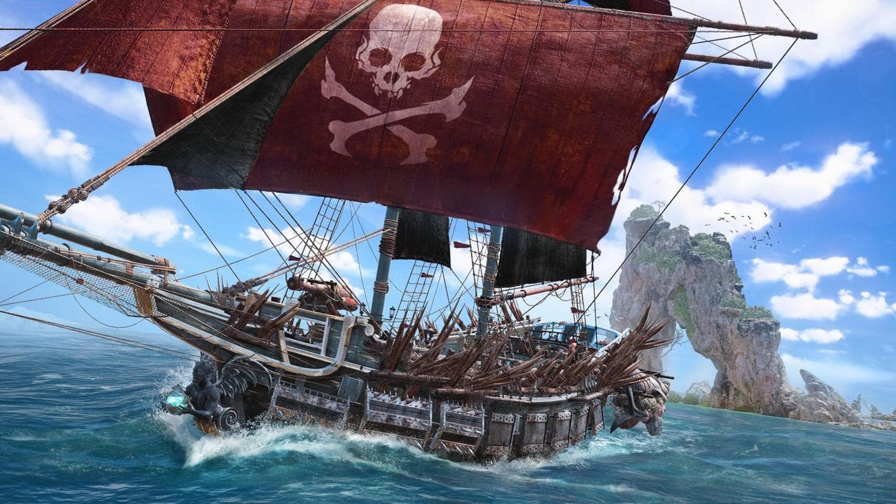 Ημερομηνία κυκλοφορίας Skull and Bones: ένα περίπλοκα διακοσμημένο πειρατικό πλοίο πλέει προς το μέρος μας, επιδεικνύοντας προσαρμοσμένες σημαίες, αιχμηρή πανοπλία και μια μυστικιστική κεφαλή