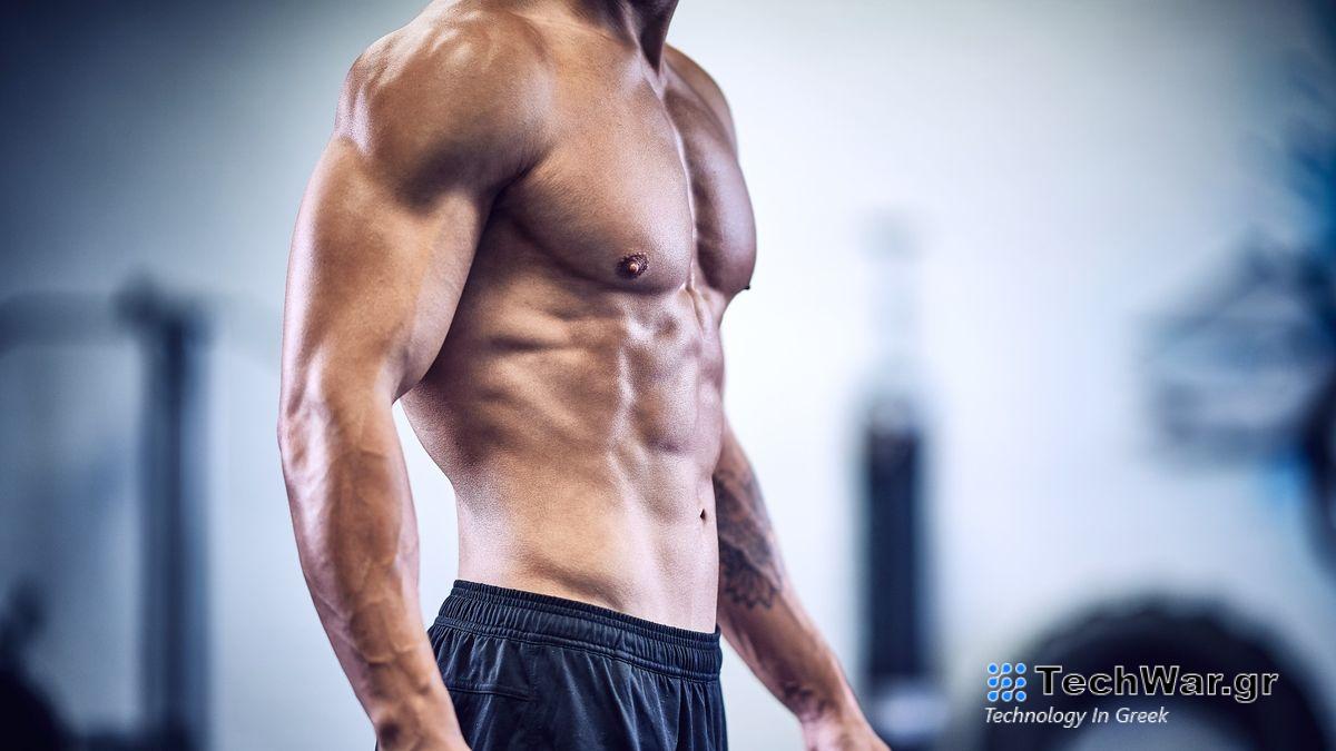 Man standing with top off showing muscled torso from side