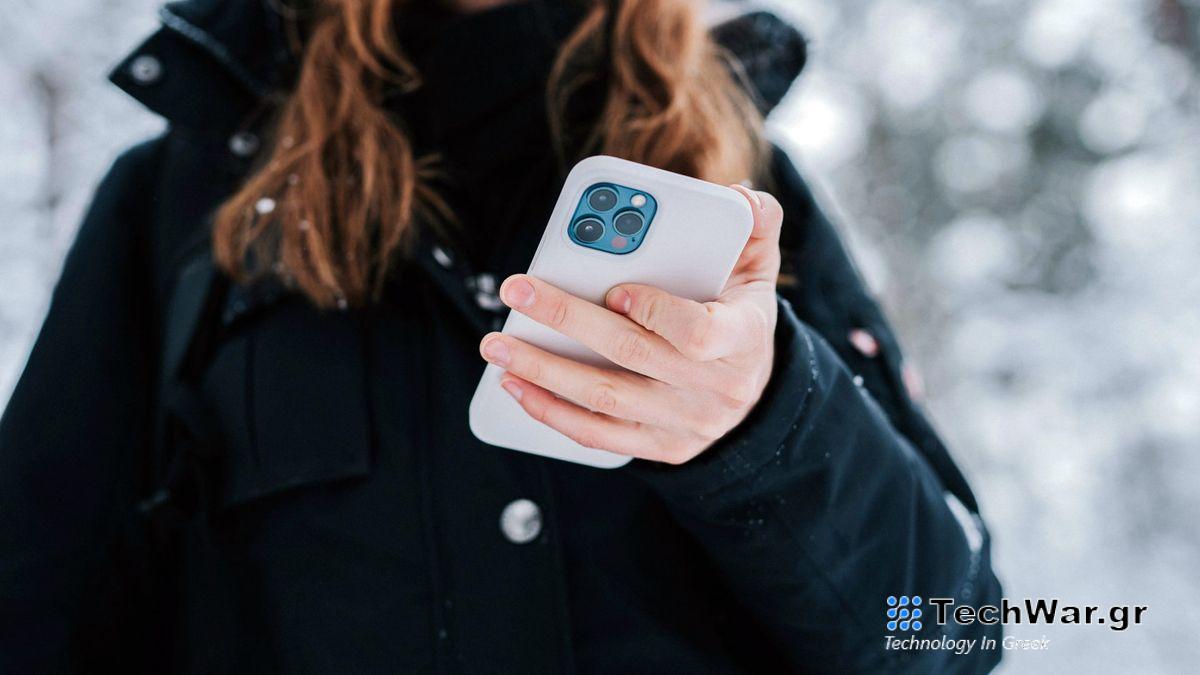 A person holds an iPhone in a white case.