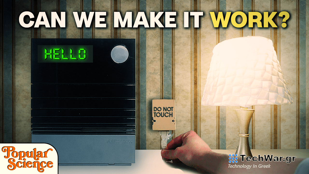 a black box with the word "hello" in green letters sits on a table next to a lamp