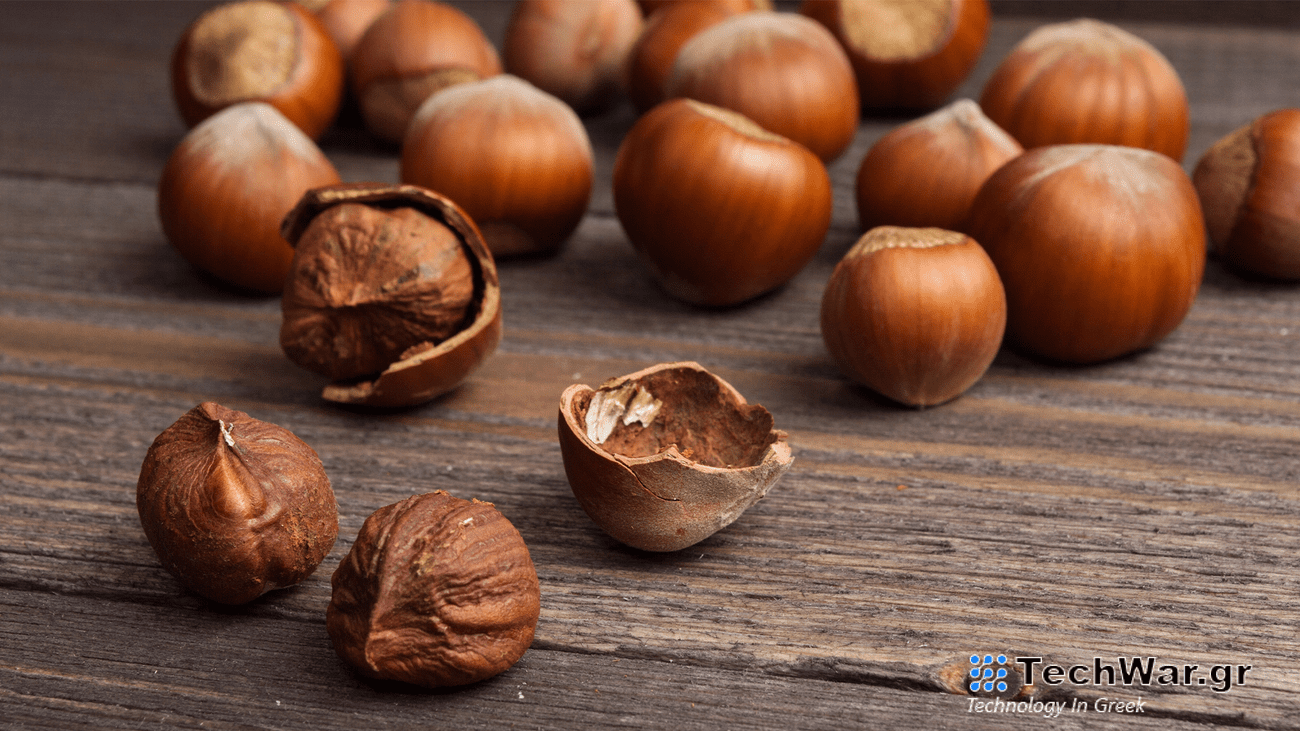 Shelled and unshelled hazlenuts on a wooden table.