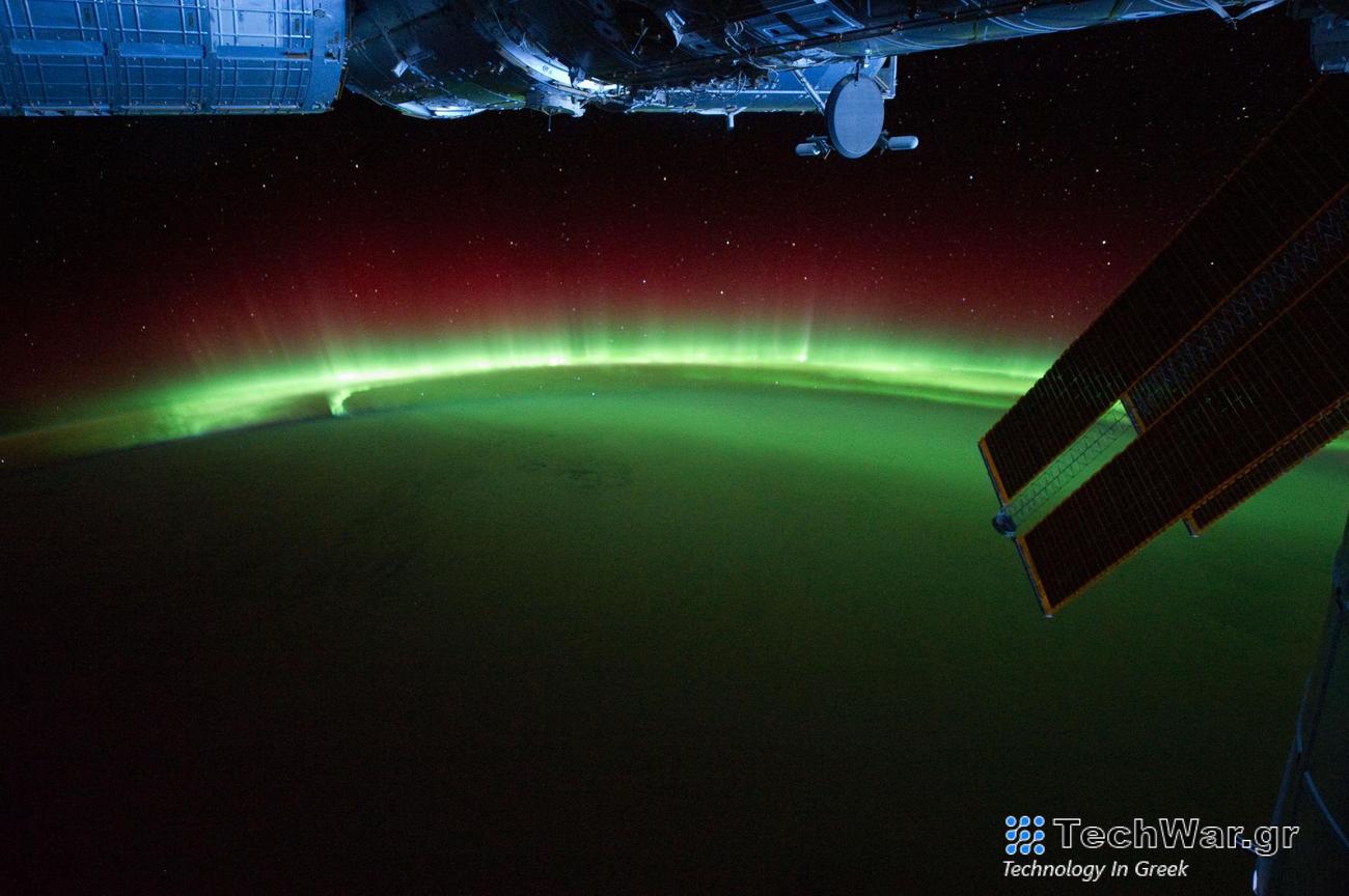 a green and red aurora with a space craft in the foreground
