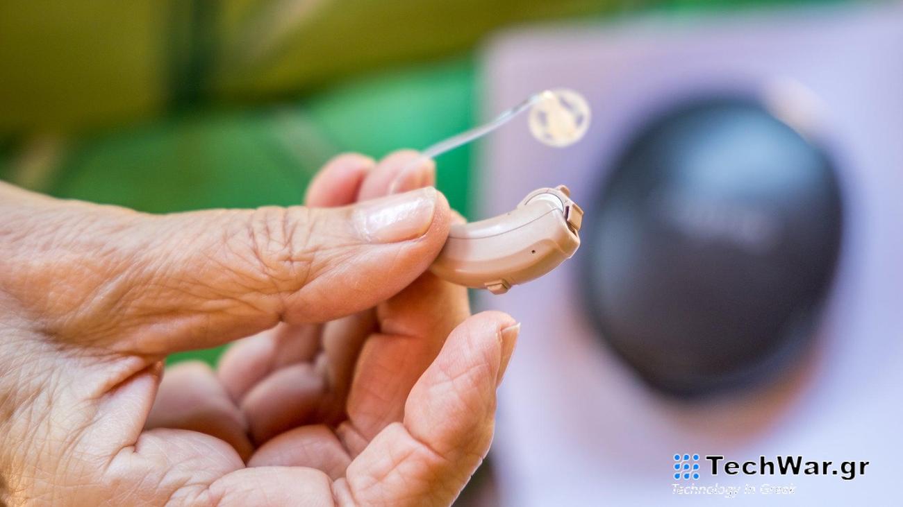 Close-up of senior woman holding a modern hearing aid