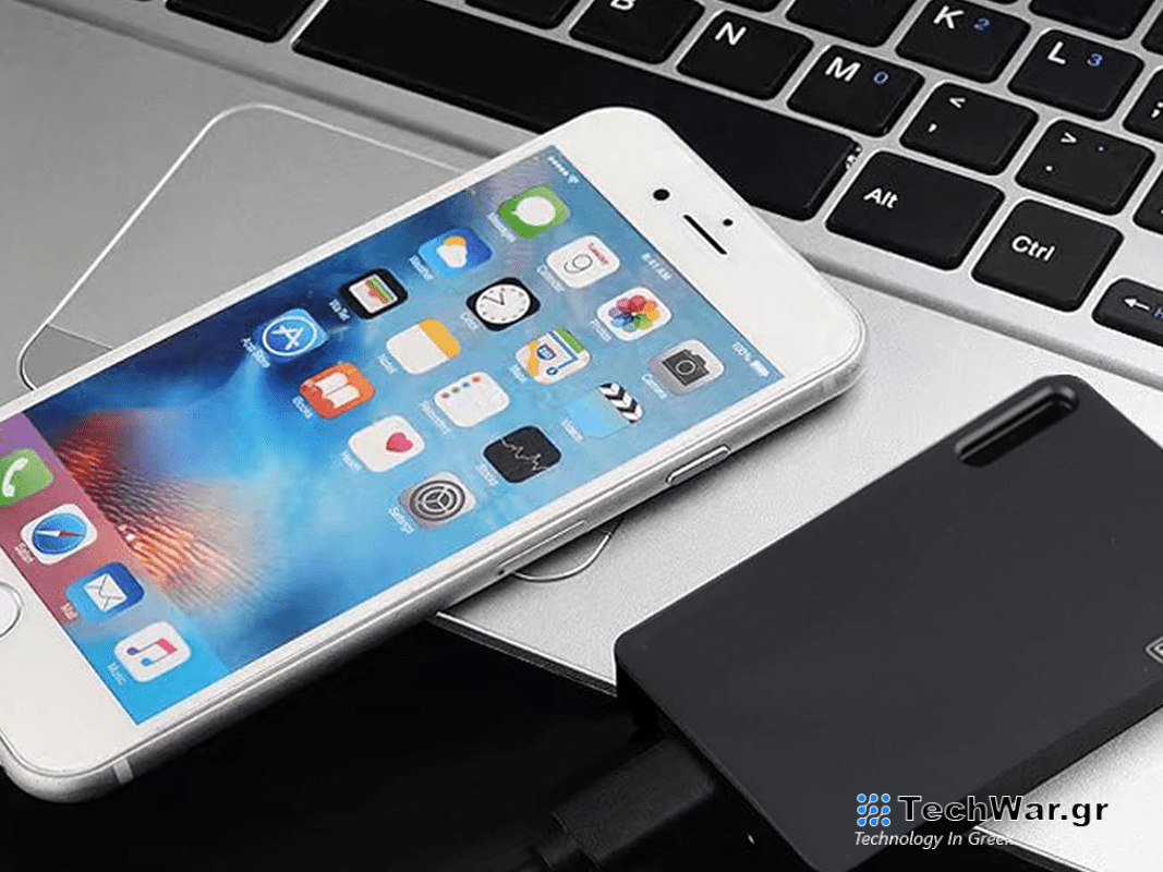 A phone and a portable SSD laying on a laptop.