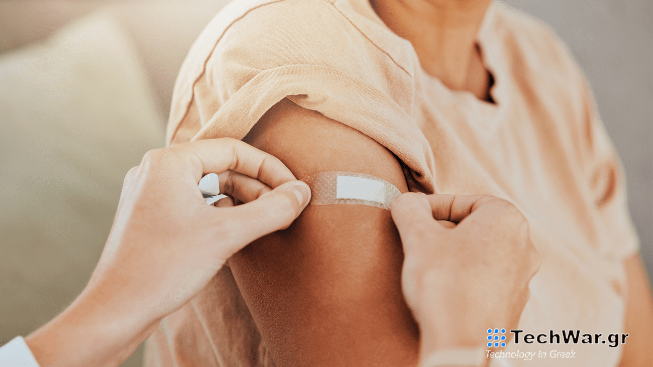 A doctor puts a bandage on the upper arm of a senior citizen.