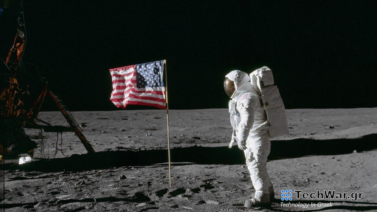 Buzz Aldrin on the moon next to American flag.